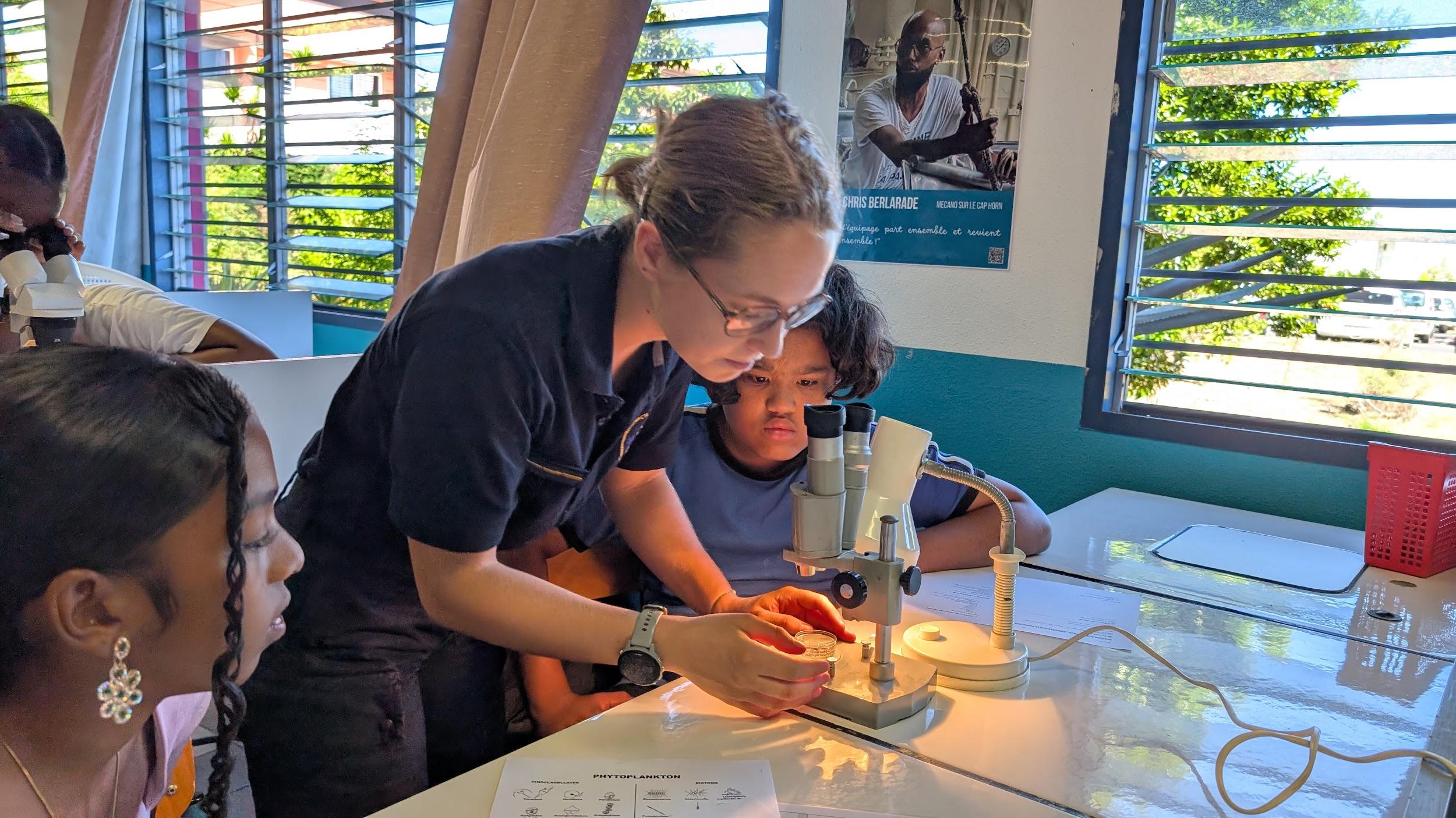 L'aspirant Adele aide les 5eme du collège Titan à utiliser la loupes binoculaires pour observer du plancton.